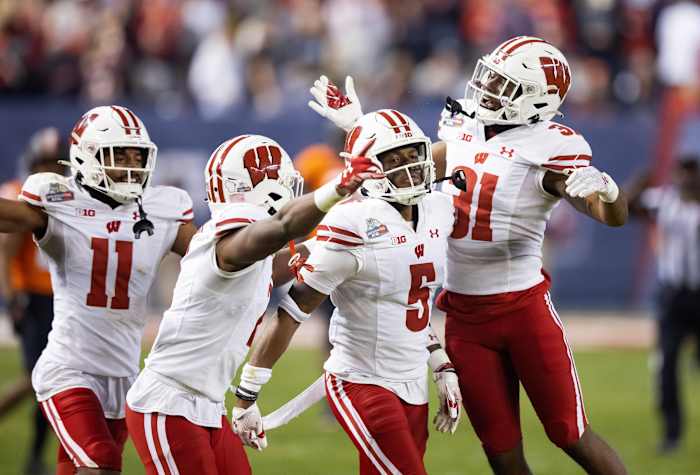 Dec 27, 2022; Phoenix, Arizona, USA; Wisconsin Badgers cornerback Cedrick Dort Jr. (5) celebrates with teammates after intercepting a pass against the Oklahoma State Cowboys in the second half of the 2022 Guaranteed Rate Bowl at Chase Field. Mandatory Credit: Mark J. Rebilas-USA TODAY Sports